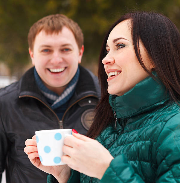 istock Happy couple having fun in winter park drinking hot tea 606009772