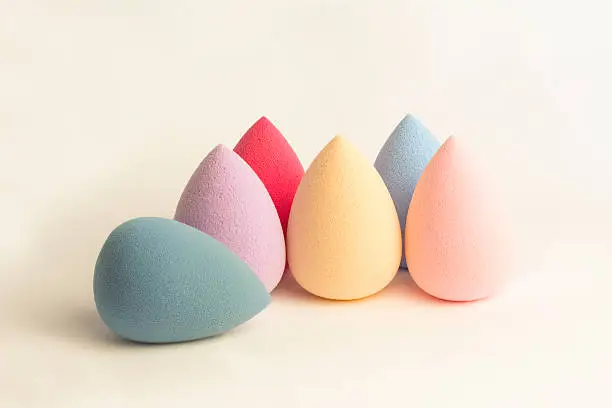 Color cosmetic sponges on a grey background closeup