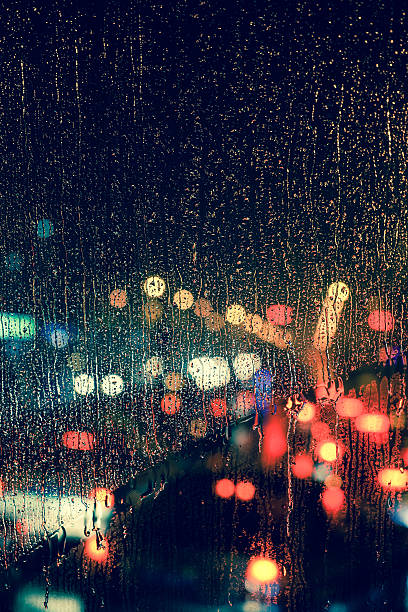 gotas de lluvia en la ventana con bokeh luz de carretera - nightlife city night rain fotografías e imágenes de stock