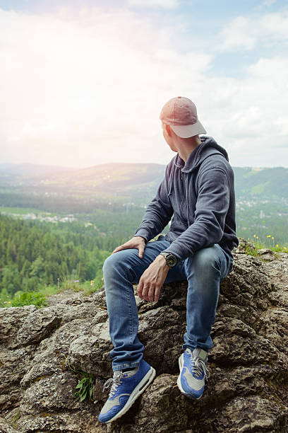 istock Male resting and enjoying the mountain sitting on rock 606010888