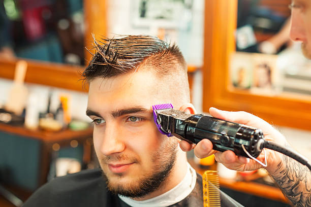 istock Young man having hair cutted 606015150