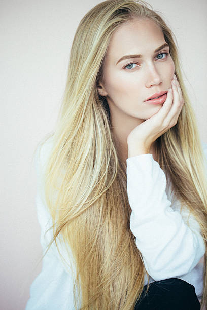 Studio shot of young beautiful woman on light background. Professional make-up and hairstyle.