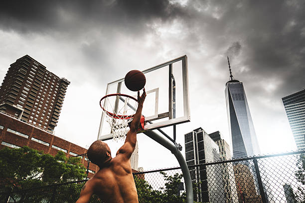 street basketball player doing a slam dunk