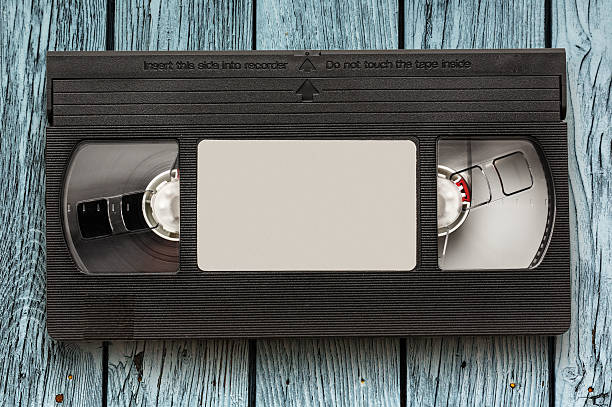 Black video cassette Black video cassette on the wooden background audio cassette blank vcr film reel stock pictures, royalty-free photos & images