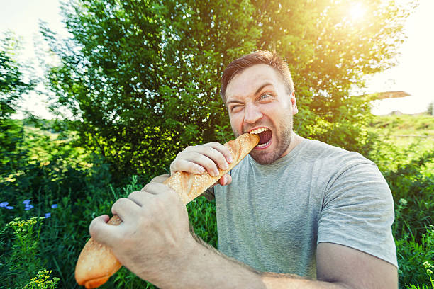 istock Man eating French bread 606018696