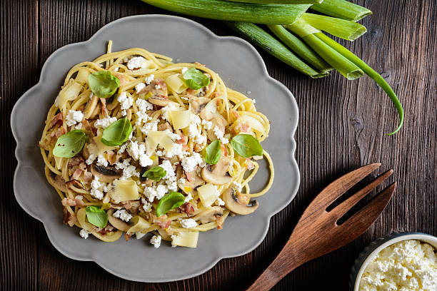Spaghetti pasta salad with fried bacon, mushrooms, green onion, cottage cheese and Gouda