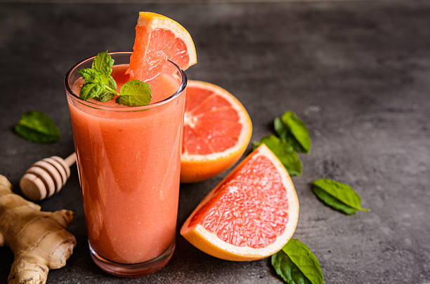 Grapefruit smoothie with ginger and honey Grapefruit smoothie with ginger root and honey in a glass jar grapefruit stock pictures, royalty-free photos & images