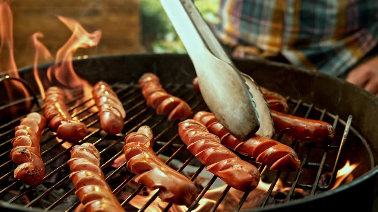 SLO MO Flipping hot dogs while grilling