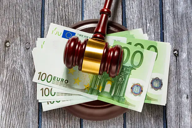 Wooden judge's gavel and one hundred euro banknotes