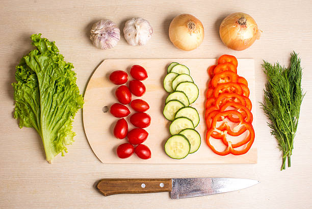 istock Vegetables, chopping board and knife on a table 606203528