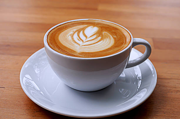 istock Coffee in white cup on wooden table. 606204724