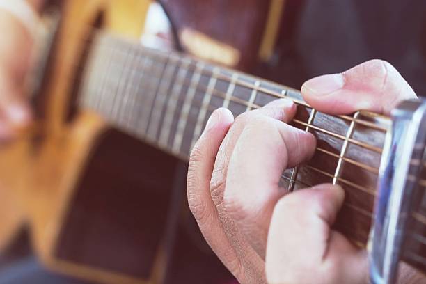 istock Practicing in playing guitar, Hand of young men playing guitar 606205466