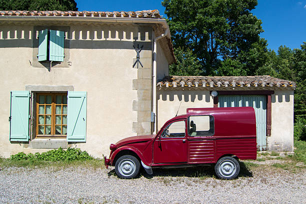 глубокий красный 2cv фургон, стоящий перед домом - citroën 2cv стоковые фото и изображения