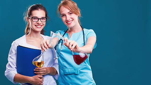 duas cientistas mulheres trabalhando em laboratório com frascos - healthcare and medicine digital tablet medical exam doctor - fotografias e filmes do acervo