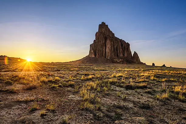 Sunset above Shiprock. Shiprock is a great volcanic rock mountain rising high above the high-desert plain of the Navajo Nation in New Mexico, USA