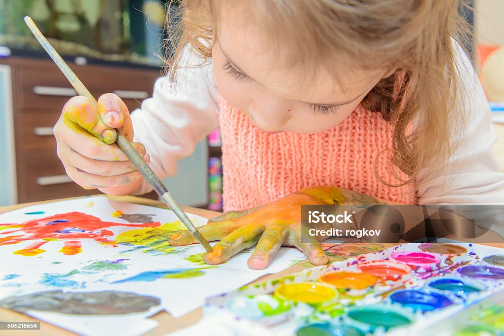 drawing by paints girl drawing paints on paper and hands Child Stock Photo