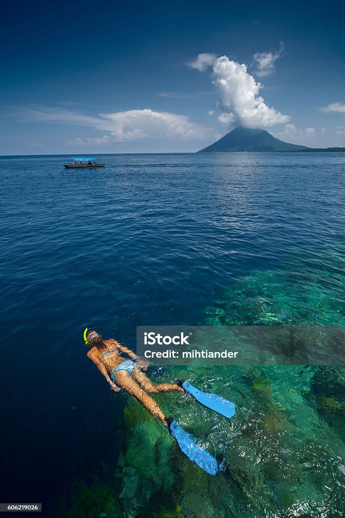 Lady snorkeling over reef wall Lady snorkeling over reef wall in the area of the island of Bunaken, Sulawesi, Indonesia Indonesia Stock Photo
