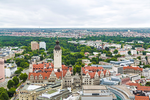 Zoomed-in perspective of Gdansk's Old Town as seen from Gradowa Hill. The focal point of the composition is the Clock Tower of Gdansk Main Station (Gdańsk Główny), standing prominently in the center of the frame. Surrounding the tower, numerous old buildings with vibrant red roofs fill the scene, showcasing the architectural charm of the historic district. This close-up view provides a detailed glimpse of the unique rooftops that define Gdansk's Old Town.