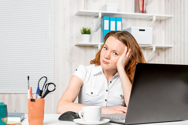 istock Young receptionist sitting behind a desk in the office 606221658