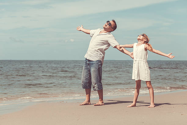 istock Father and daughter playing on the beach at the day. 606223738