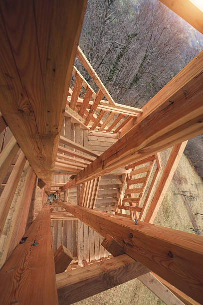High angle view of staircase with glass railings. Diminishing view of wooden steps. Interior of apartment.