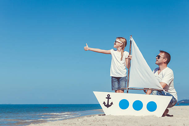 father and daughter playing on the beach at the day. - recreational boat small nautical vessel sea imagens e fotografias de stock