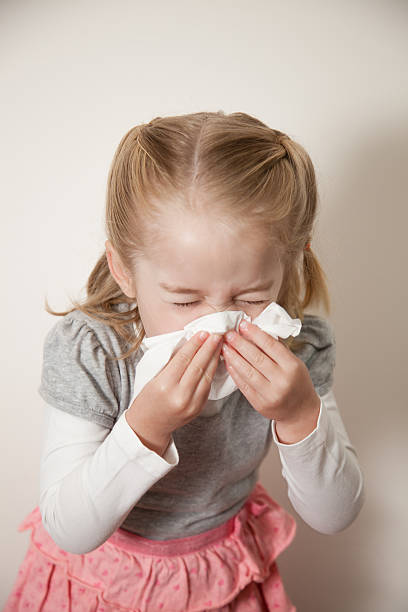 istock Little girl blowing her nose 606224896
