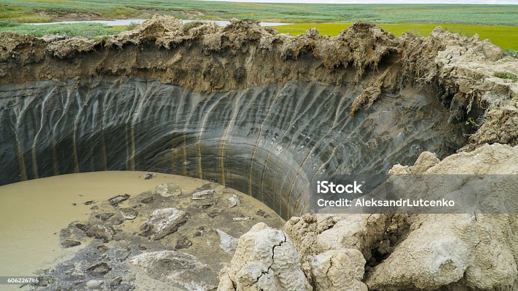 YAMAL PENINSULA, RUSSIA - JUNE 18, 2015: Expedition to the YAMAL PENINSULA, RUSSIA - JUNE 18, 2015: Helicopter expedition to the giant funnel of unknown origin. Crater view. Permafrost Stock Photo
