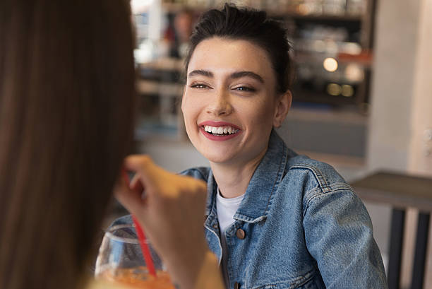 istock cheerful girl talking with her friend 606228228