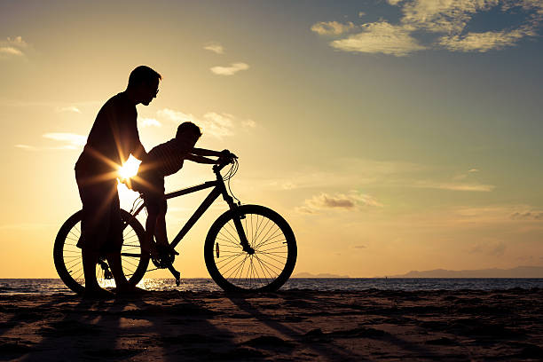 istock Father and son playing on the beach at the sunset. 606230894