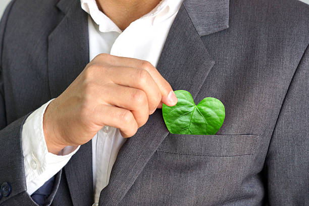 Green business Businessman putting a green leaf with a heart shape from his pocket / Green business / Business with corporate social responsibility and environmental concern responsible business stock pictures, royalty-free photos & images