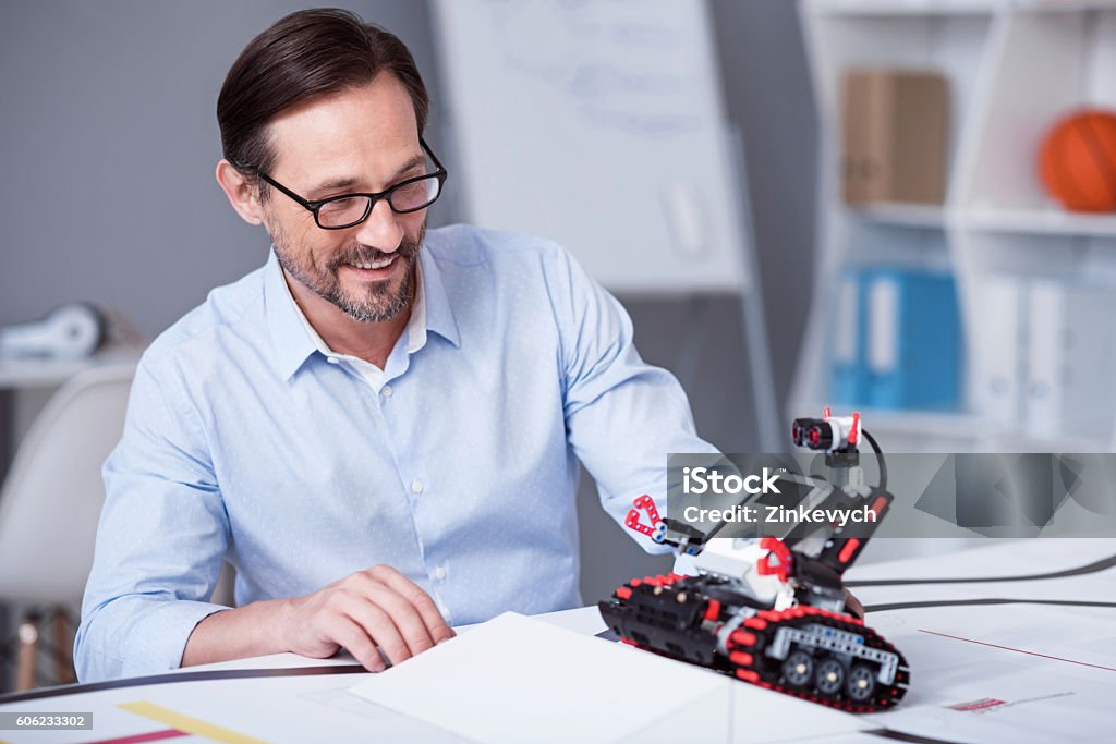 Alter Mann wird verlassen, um einen kleinen Roboter zu testen - Lizenzfrei Erfinder Stock-Foto