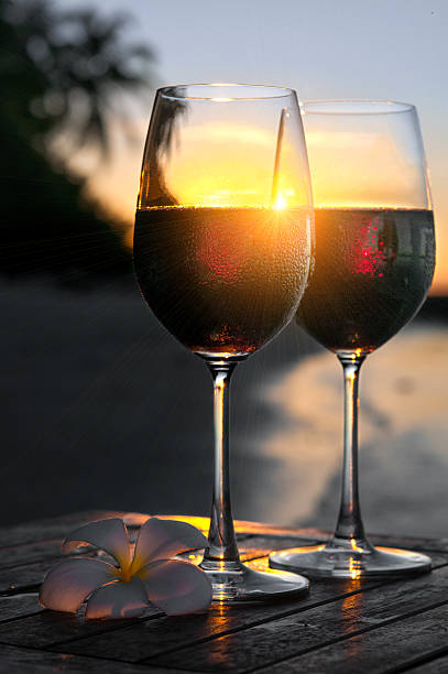 istock Romantic beach scene: two glasses of red wine at sunset 606234852