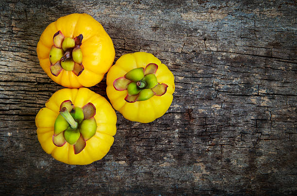 Garcinia cambogia fresh fruit on wood background. stock photo