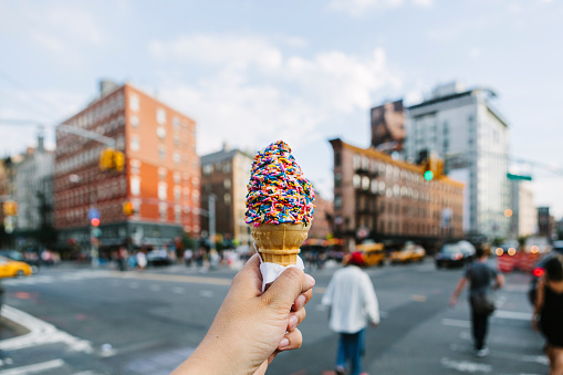 A hand holding ice cream in New York City.