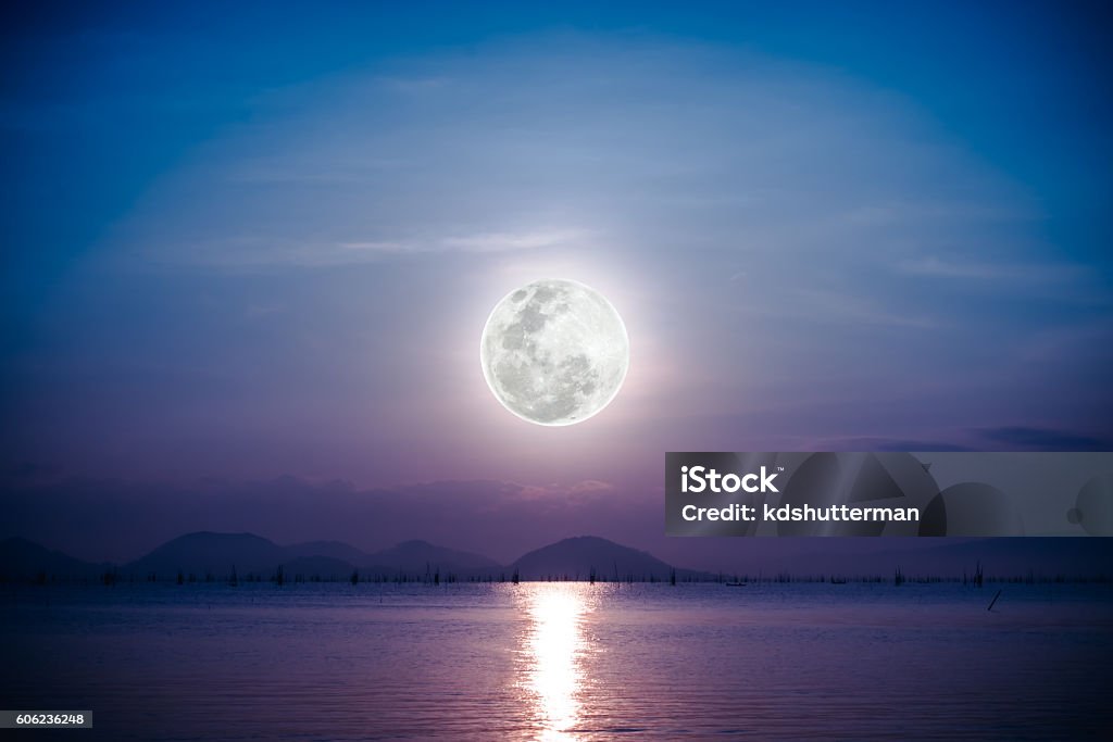 Romantic scenic with full moon on sea to night. Fantastic view of the sea. Romantic scenic with full moon on sea to night. Reflection of moon in water. Vignette picture style. The moon were NOT furnished by NASA. Astronomy Stock Photo