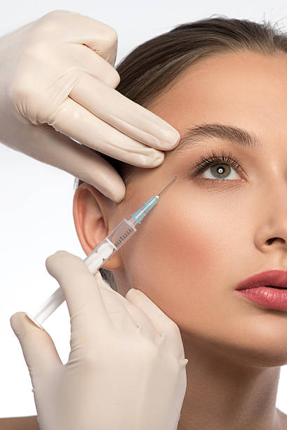 istock Experienced beautician injecting woman face 606238180