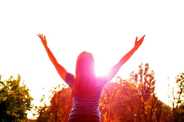 istock Young woman enjoying sunlight with raised arms 606238572