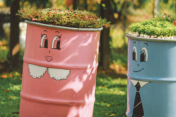 istock Plants Growing On Painted Metal Barrels In Garden 606370043