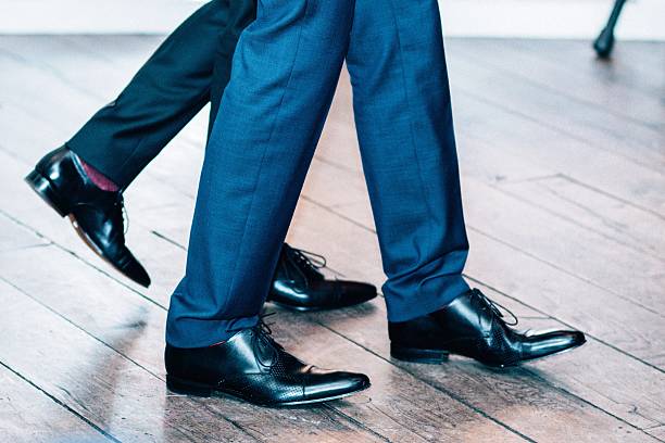 istock Low Section Of Businessmen Walking On Floorboard 606380565