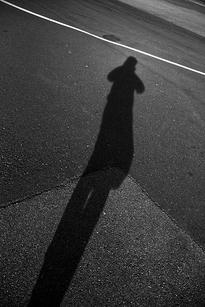 istock High Angle View Of Person Shadow On Street 606380617