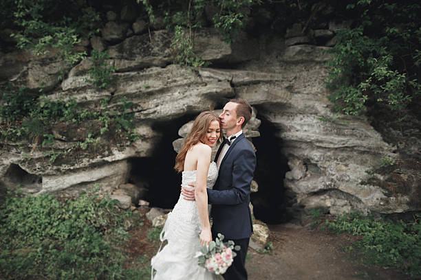 istock Cheerful married wedding couple posing nea rocks 606633474