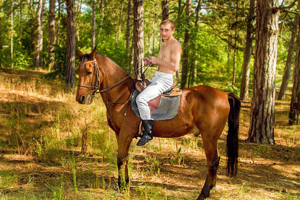 istock young man in the forest on horseback 606638636