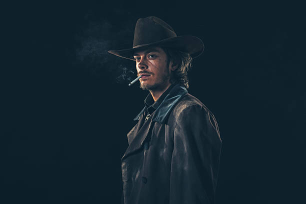 istock Retro cowboy smoking cigarette. Young man. Studio shot. 606642992