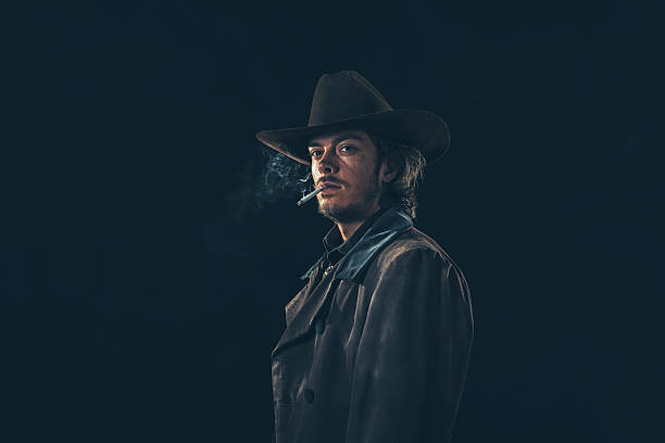 istock Retro cowboy smoking cigarette. Young man. Studio shot. 606643080