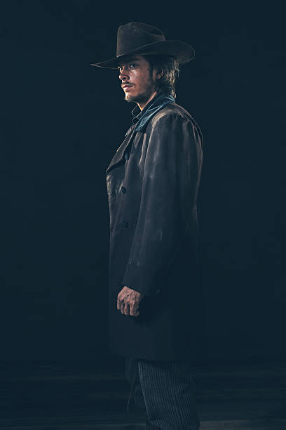 istock Side view of vintage 1900 cowboy. Young man. Studio shot. 606643218