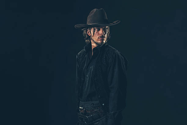 istock Alert vintage 1900 cowboy looking over shoulder. Studio shot. 606652918