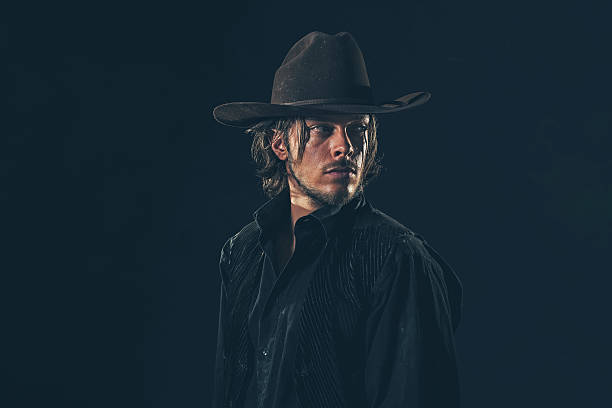 istock Alert vintage 1900 cowboy looking over shoulder. Studio shot. 606653226