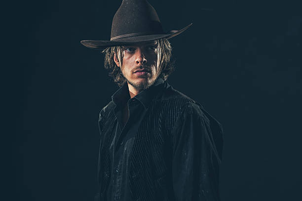istock Vintage 1900 cowboy. Young man. Studio shot against dark wall. 606655874