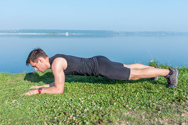 Fit man doing plank core exercise working on abdominal back Fit man doing plank core exercise working on abdominal back muscles. forearm stock pictures, royalty-free photos & images
